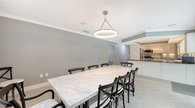 dining room with light tile patterned flooring and crown molding