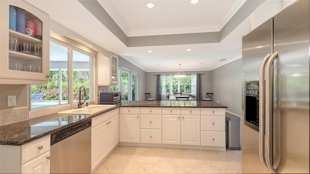 kitchen with light tile patterned flooring, stainless steel appliances, dark stone countertops, and sink