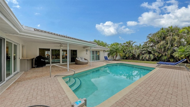 view of pool featuring a patio area, a grill, and ceiling fan