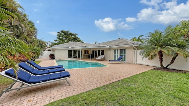 view of swimming pool featuring a lawn and a patio