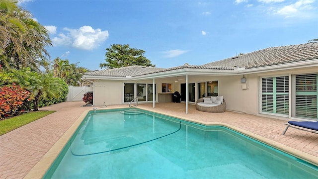 back of property featuring ceiling fan and a patio