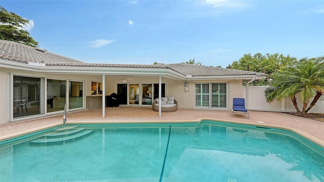 back of property featuring ceiling fan and a patio