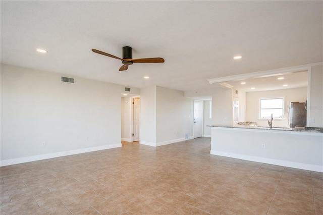 unfurnished living room with sink and ceiling fan