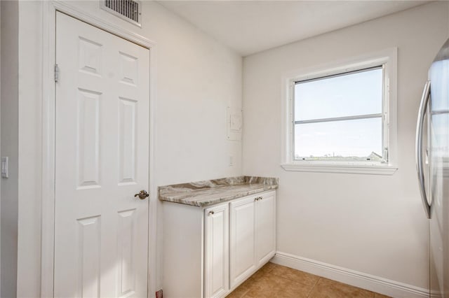 interior space featuring light tile patterned floors, cabinets, and independent washer and dryer