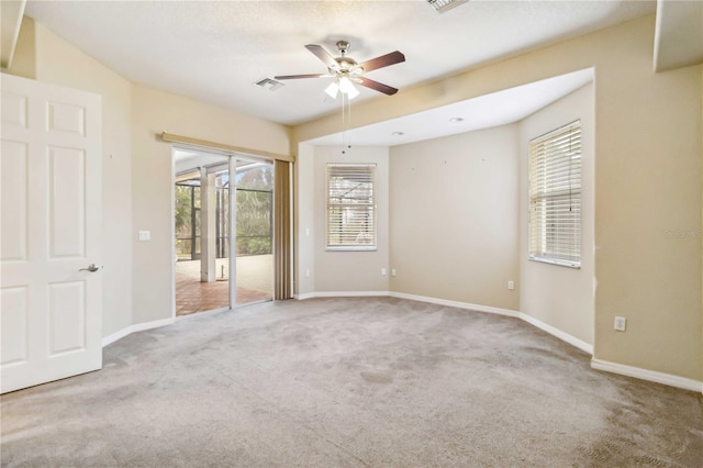 empty room featuring ceiling fan and carpet