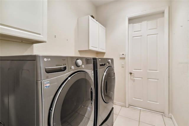 laundry area featuring light tile patterned floors, independent washer and dryer, and cabinets