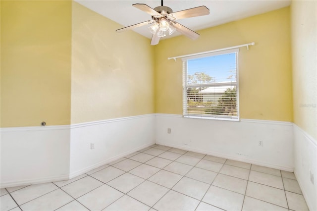 empty room with ceiling fan and light tile patterned floors