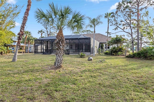 back of house featuring a lanai and a yard