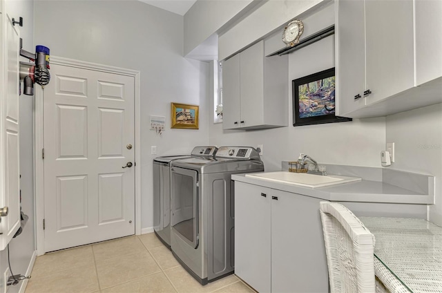 washroom featuring washer and clothes dryer, sink, light tile patterned floors, and cabinets