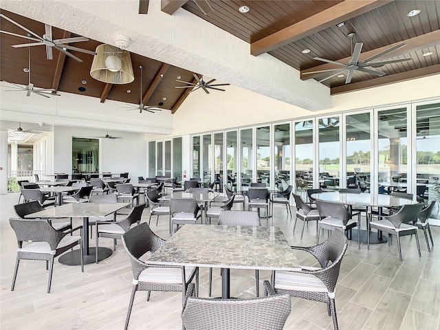 dining space featuring wood ceiling, a towering ceiling, and beamed ceiling