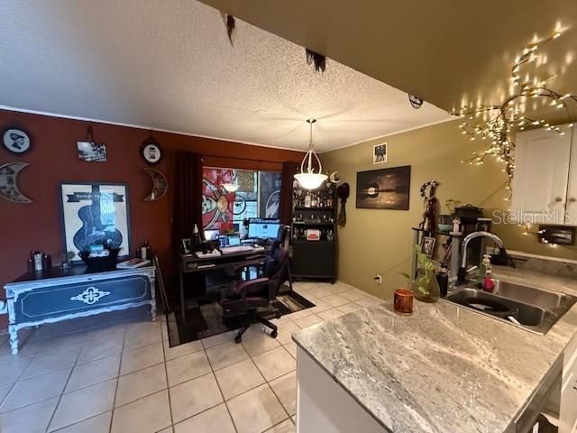 dining space featuring sink, a textured ceiling, and light tile patterned flooring