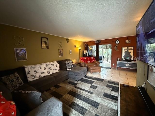 living room with light tile patterned floors and a textured ceiling