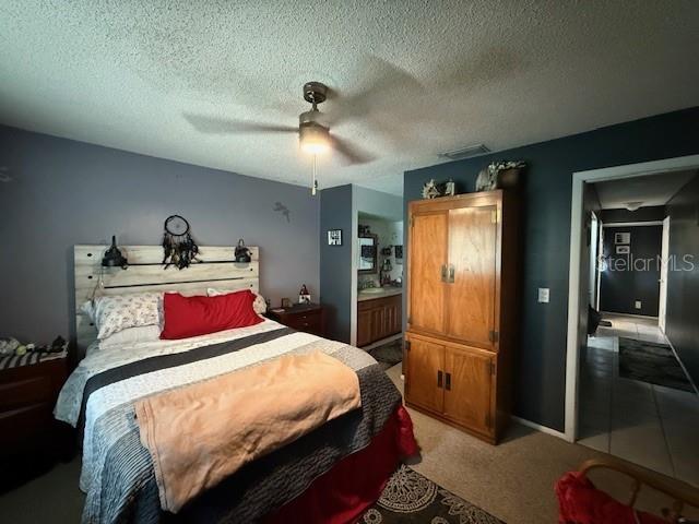 bedroom featuring ceiling fan and a textured ceiling