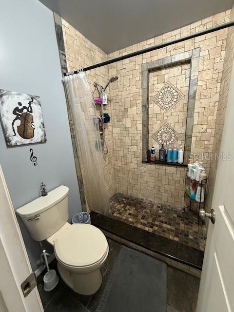 bathroom featuring toilet and a shower with shower curtain