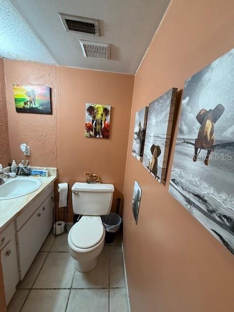 bathroom featuring tile patterned floors, vanity, and toilet