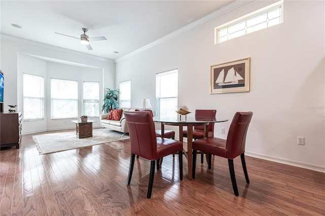 dining room with wood-type flooring, ornamental molding, and ceiling fan