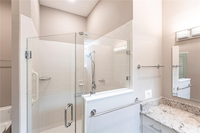 bathroom featuring vanity, an enclosed shower, and toilet