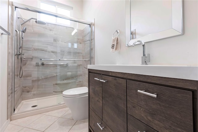 bathroom with vanity, a shower with shower door, tile patterned floors, and toilet