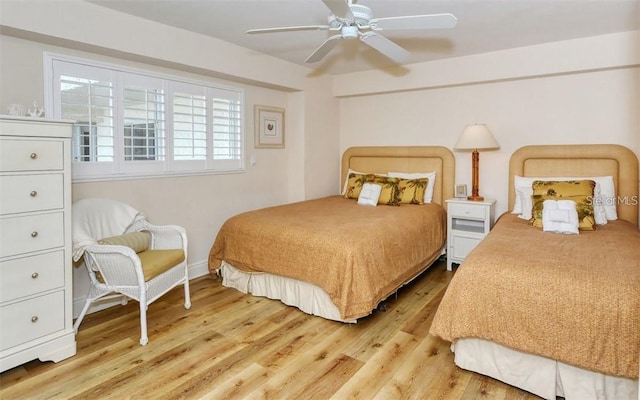 bedroom with light wood finished floors, baseboards, and a ceiling fan