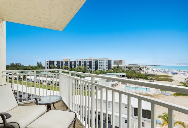 balcony featuring a view of city, a beach view, and a water view