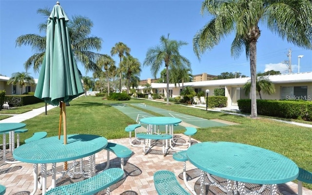 view of home's community featuring shuffleboard and a lawn