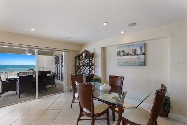 dining area with a water view, light tile patterned floors, baseboards, and recessed lighting