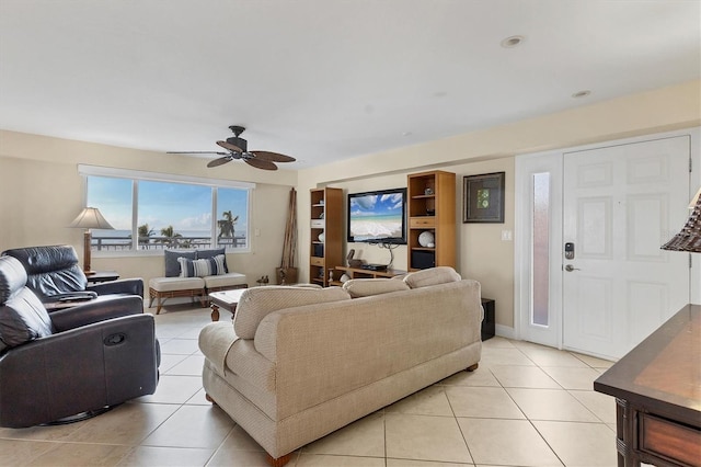 living area featuring baseboards, a ceiling fan, and light tile patterned flooring