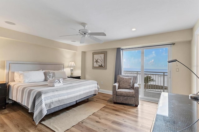 bedroom with ceiling fan, a water view, baseboards, access to exterior, and light wood-type flooring