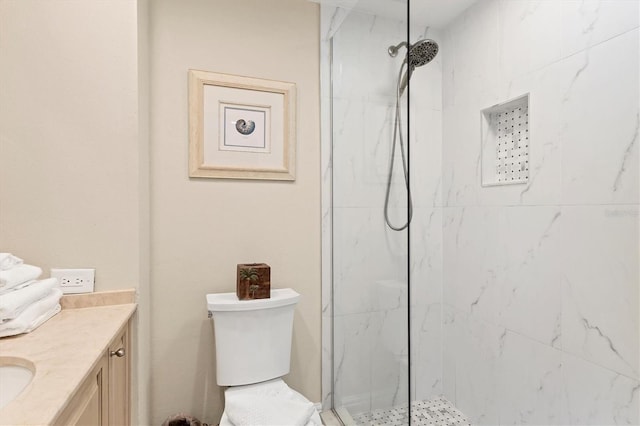 bathroom with toilet, a marble finish shower, and vanity