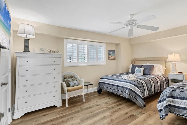 bedroom featuring a ceiling fan, baseboards, and wood finished floors