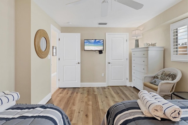 bedroom featuring light wood-type flooring, baseboards, visible vents, and ceiling fan