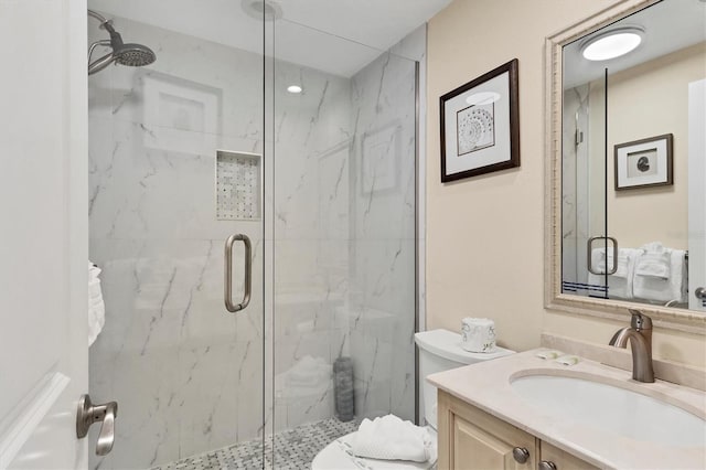 full bath featuring toilet, vanity, and a marble finish shower