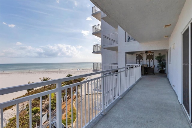 balcony featuring a water view and a beach view