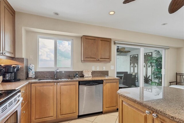 kitchen with ceiling fan, light tile patterned flooring, a sink, appliances with stainless steel finishes, and light stone countertops