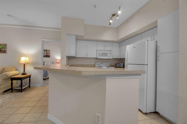 kitchen featuring white appliances, kitchen peninsula, and white cabinets