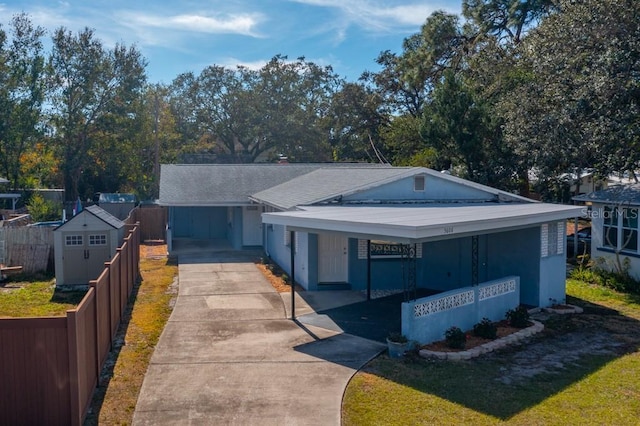 ranch-style home featuring a carport and a storage shed