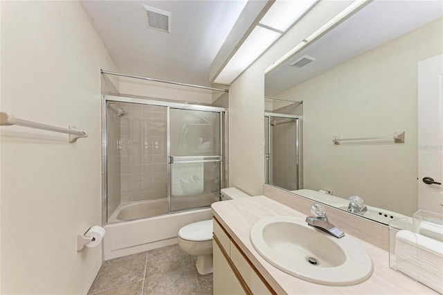 full bathroom featuring tile patterned flooring, vanity, combined bath / shower with glass door, and toilet