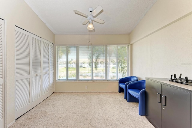 sitting room with a textured ceiling and ceiling fan