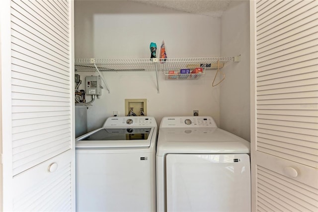 washroom with washing machine and dryer and a textured ceiling