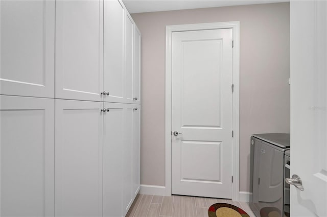 washroom featuring washing machine and clothes dryer and cabinets