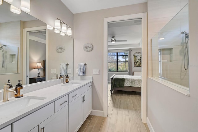 bathroom with ceiling fan, walk in shower, and vanity