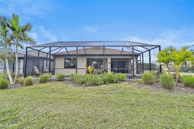 rear view of property featuring a lanai and a yard