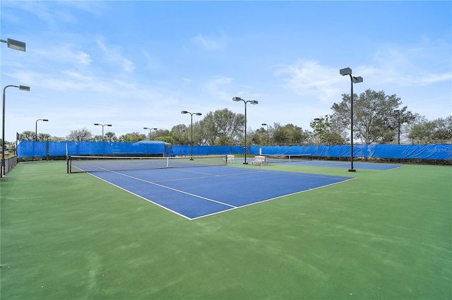 view of tennis court featuring basketball hoop