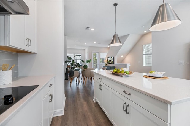 kitchen featuring premium range hood, decorative backsplash, dark wood-type flooring, hanging light fixtures, and white cabinets