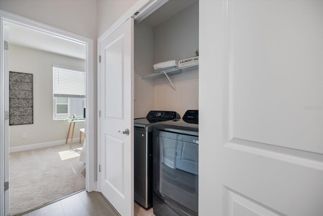 laundry room featuring washing machine and dryer and light carpet