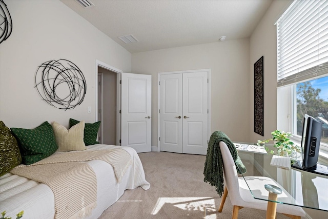 bedroom featuring light colored carpet and a closet