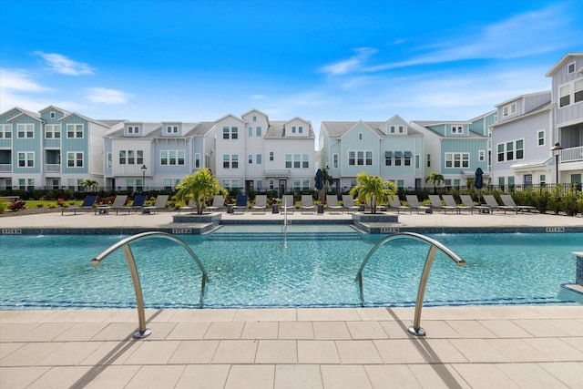 view of swimming pool with pool water feature and a patio