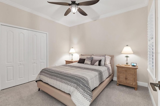 carpeted bedroom featuring ceiling fan, a closet, and ornamental molding