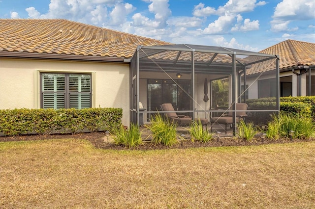 rear view of house with a lanai and a yard