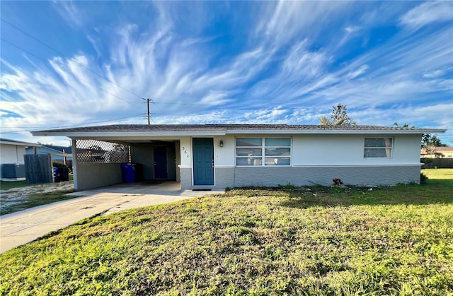 ranch-style home featuring a carport and a front yard